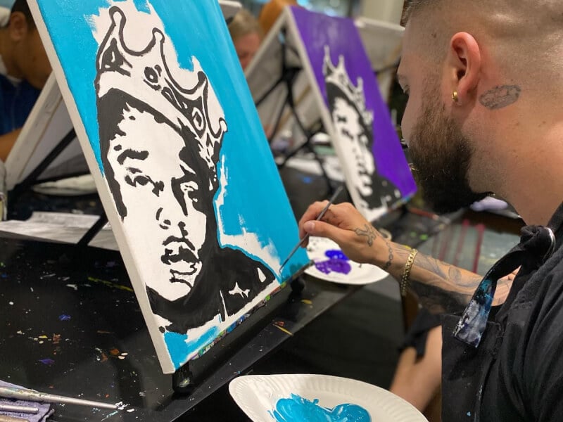 man painting at sip and paint class with Drip Splash